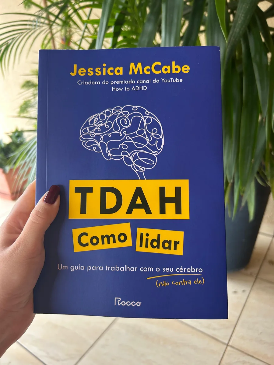 Livro TDAH: Como Lidar, de Jessica McCabe, em frente a uma planta