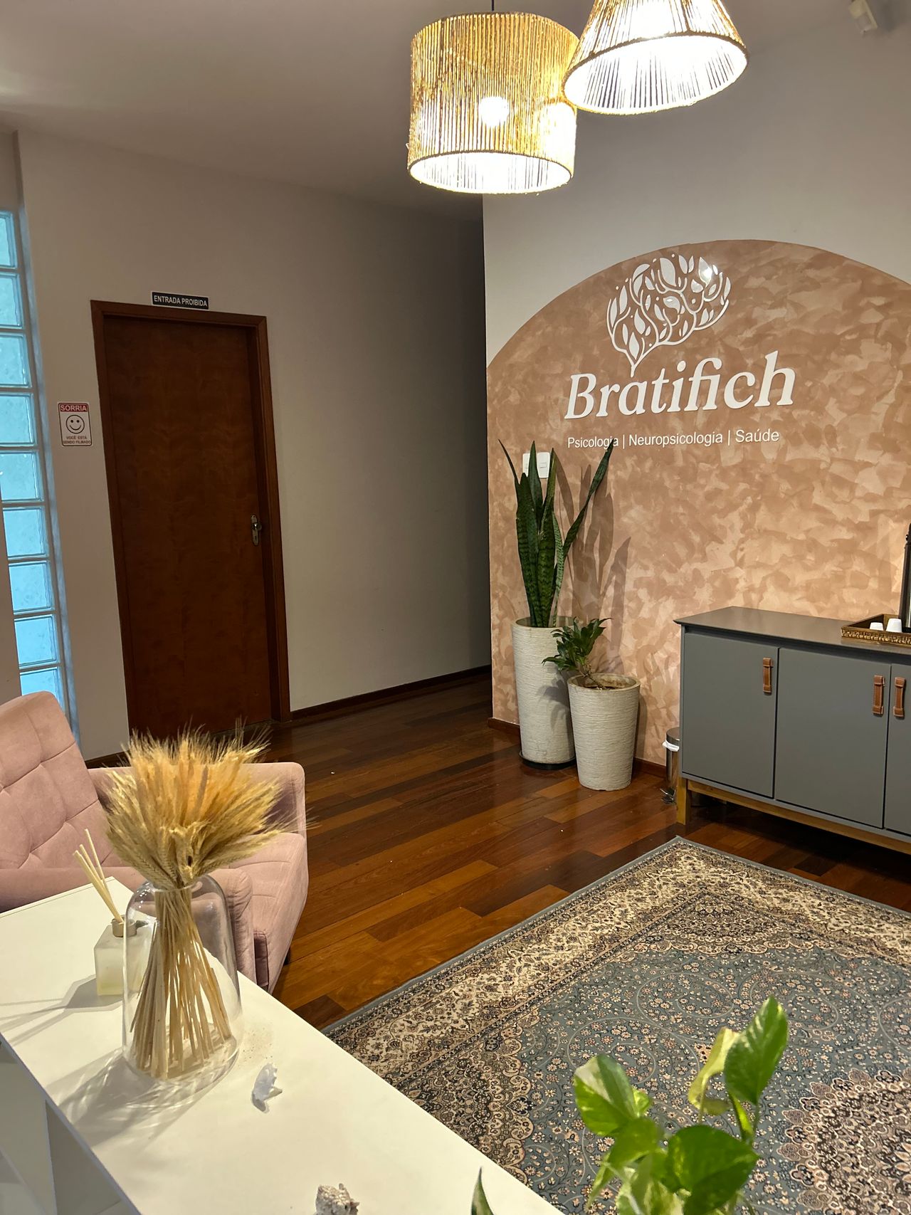 Recepção da clínica com plantas e iluminação acolhedora